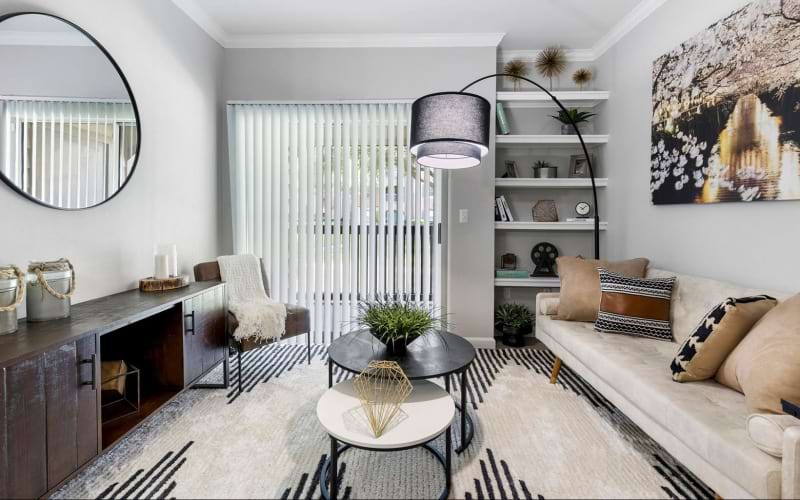 lighted living room with sliding door access to private patio